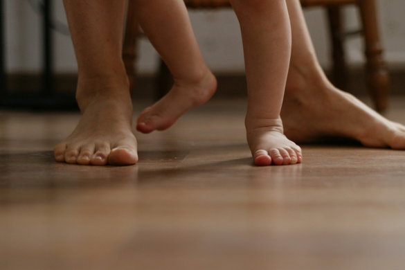a-close-up-of-a-child-s-bare-feet-on-a-wooden-floor.jpg a close up of a child's bare feet on a wooden floor